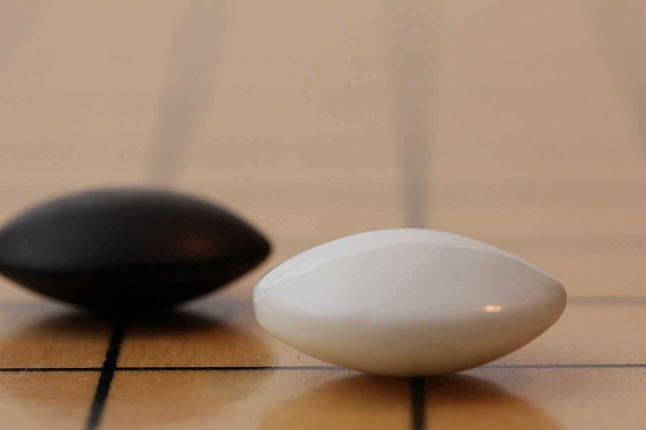 There are so many little things to get right with this photo. It was mildly annoying. Interesting note: I moved the focal plane to blur the imperfections on the front face of the stone and enhance the sharpness around its silhouette. Shot with room lighting for highlights and to neutralize the reflections on the board and a bounce flash to bring out the curve on the stones.