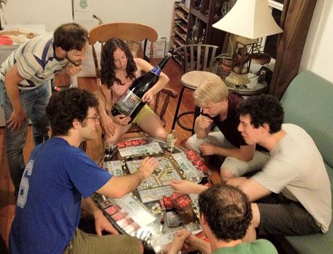 A group of board gamers play the board game "Robo Rally"