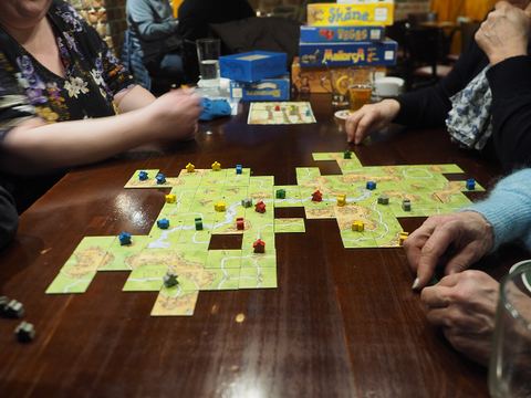 A five-player game of Carcassonne in the middle of play at restaurant Kaisla in Kaisaniemi, Helsinki, Finland.