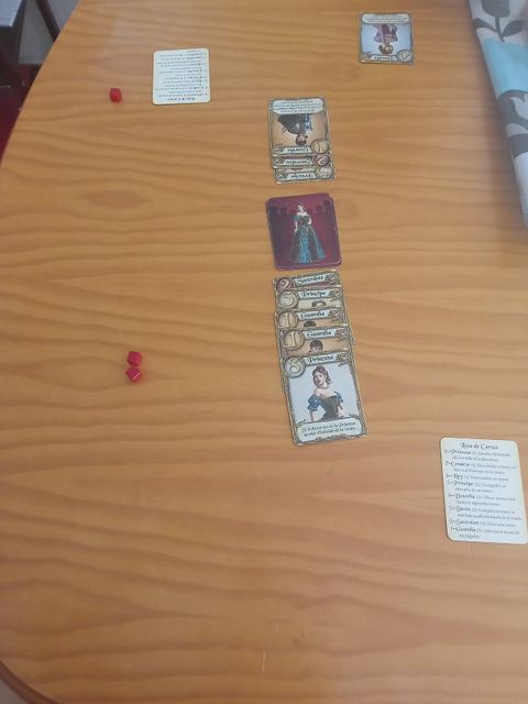 Muestra de una partida de Love Letter, con las prendas del juego, el mazo y las cartas descartadas por los jugadores
