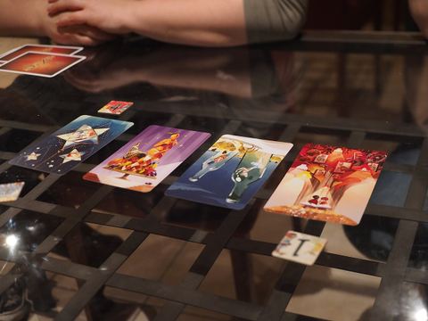 Voting for cards in a game of Dixit in Korpilampi, Espoo, Finland. Here the red player has voted for card #4 and the white player has voted for card #1.